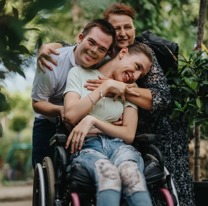 Two disabled friends with carer