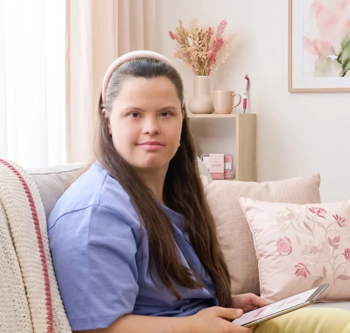 Cute girl with disability using tablet while sitting sofa living room