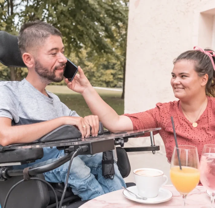 Nurse helping disability men use mobile phone while they enjoy
