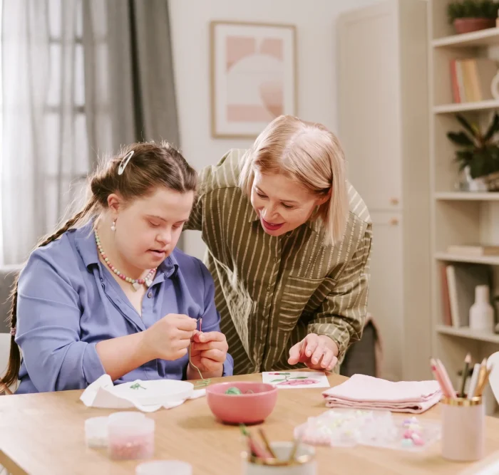Woman teaching her daughter how to embroider